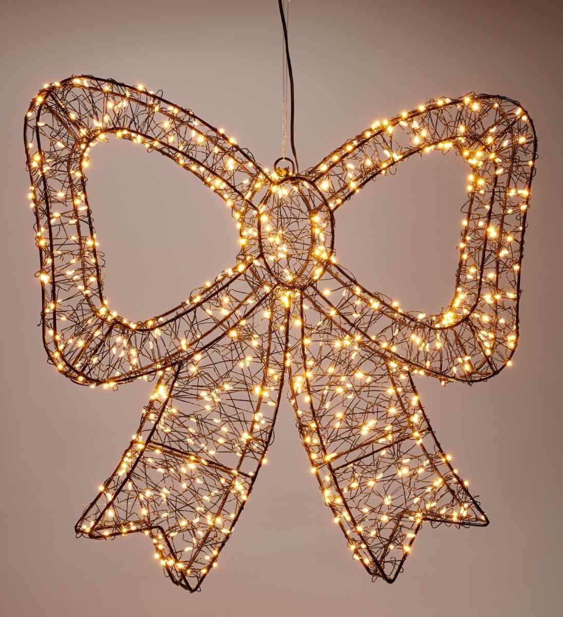 Verlichte kerststrik van 38 cm met extra warmwitte leds aan een donkere wand
